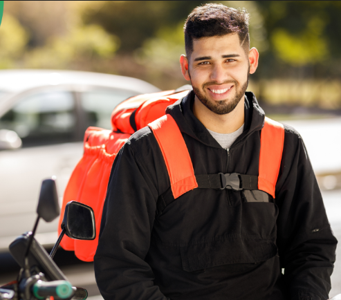 Entregador sorrindo com mochila de entregas ao lado da moto